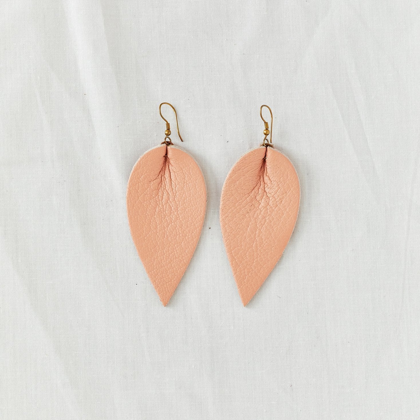 Classic design that transitions effortlessly from day to night, these blush leather leaf earrings are handcrafted from sustainable leather.