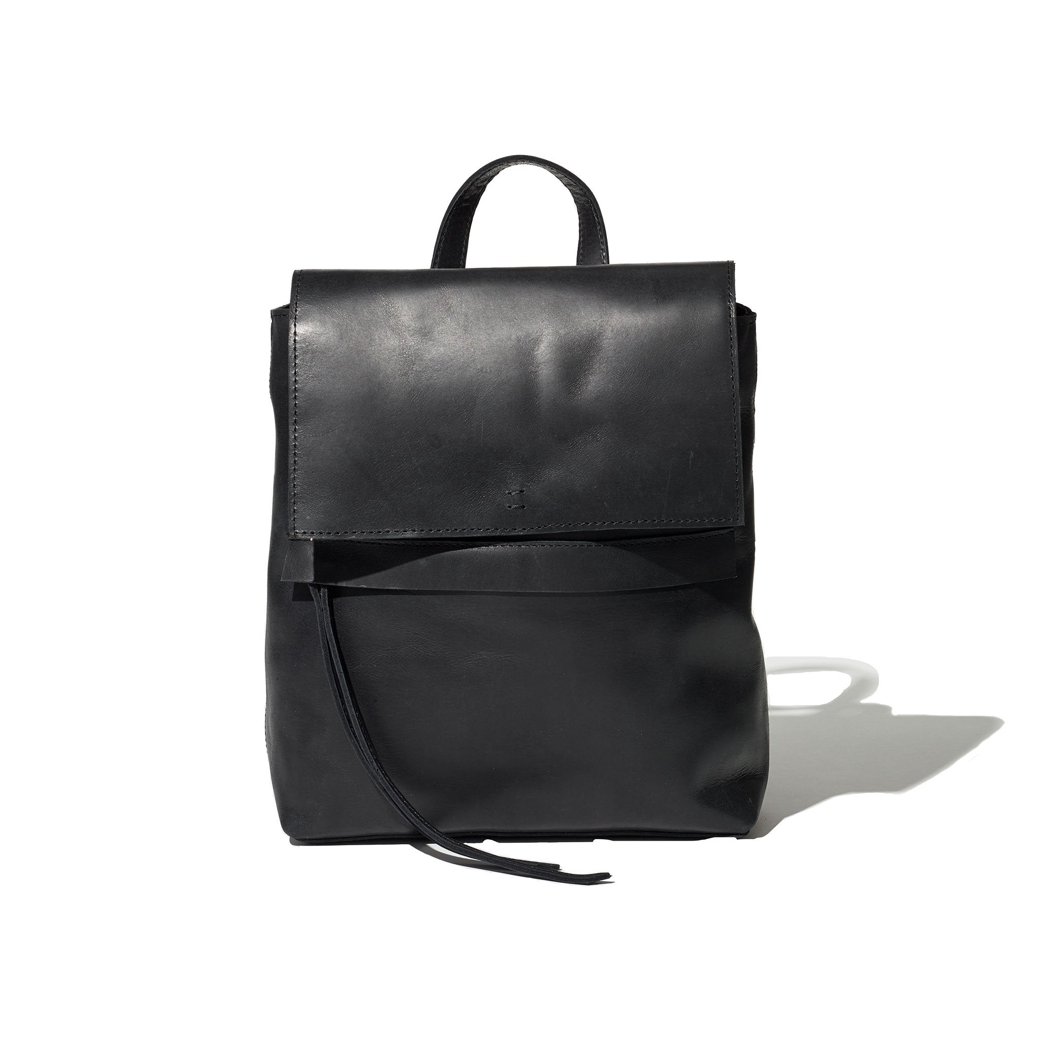 Black backpack handcrafted from sustainable Ethiopian leather featuring a hand-loomed cotton lining and adjustable straps.