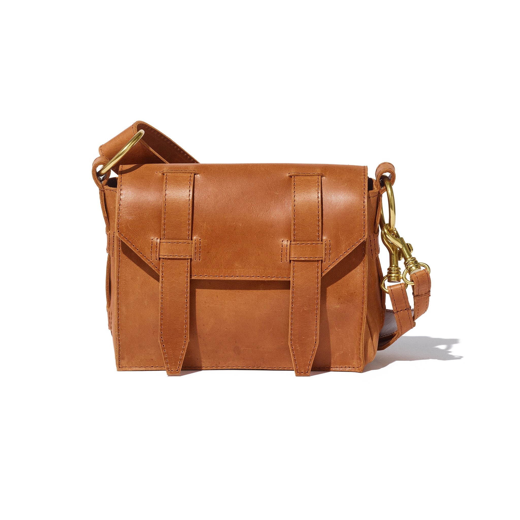 A versatile brown crossbody bag handcrafted from sustainable leather, lined with hand-loomed cotton, that features a removable strap and an interior card slot.