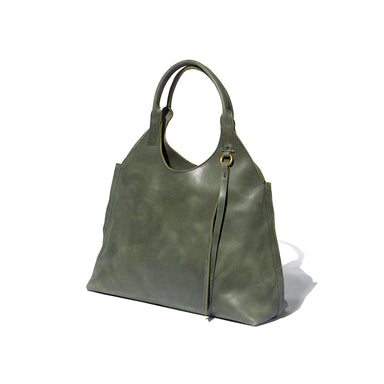 A green tote bag with a 1970's silhouette handcrafted from sustainable leather and lined with 100% Ethiopian cotton.