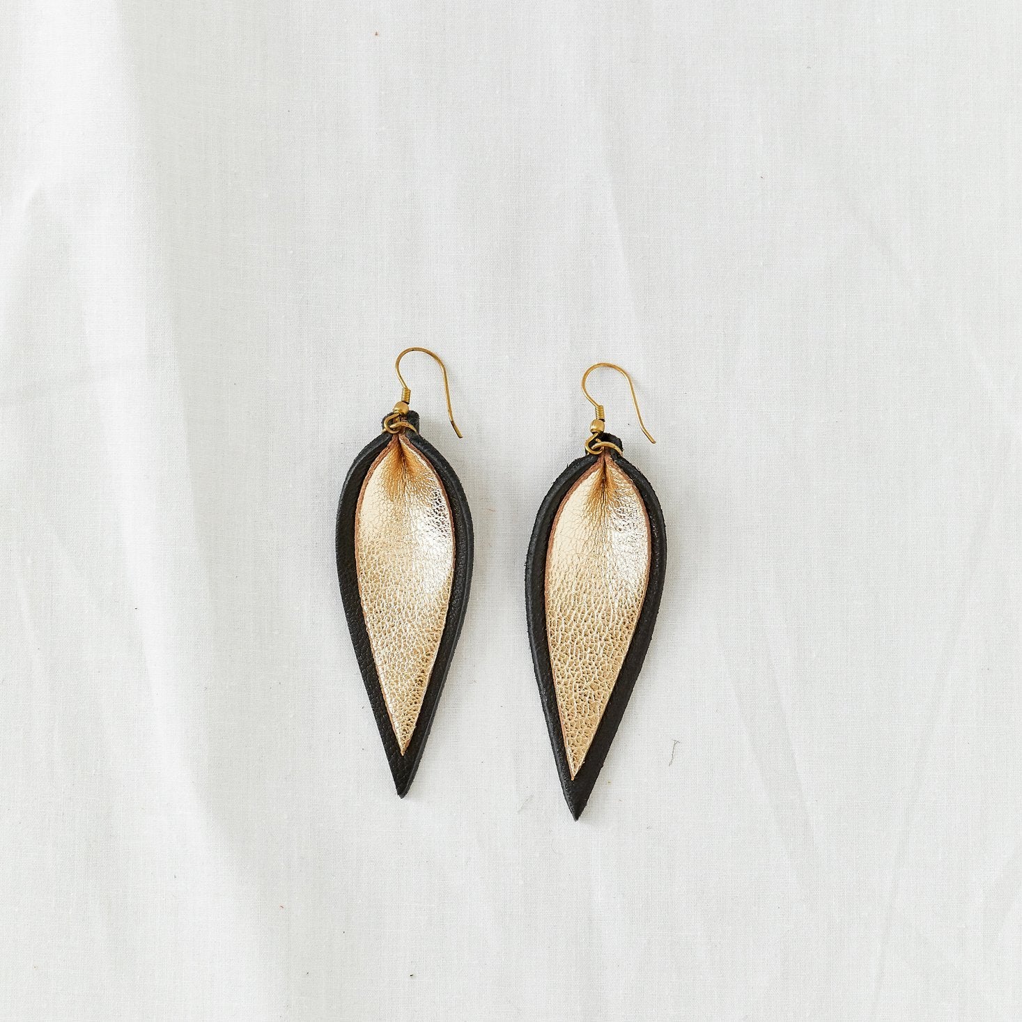 Classic design that transitions effortlessly from day to night, these black and gold leather leaf earrings are handcrafted from sustainable leather.