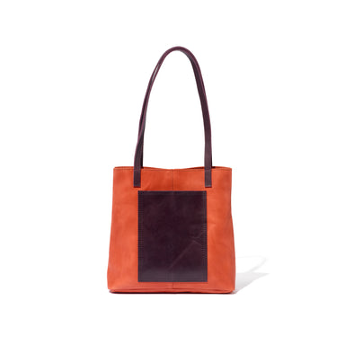 Just the right size for everyday, this red and purple tote is handcrafted from sustainable leather and features an exterior pocket.
